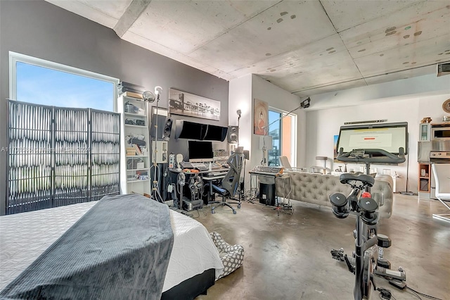 bedroom with concrete floors and multiple windows