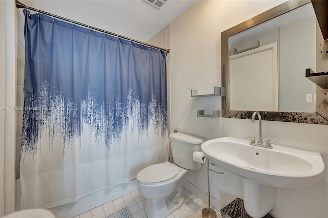 full bathroom featuring tile patterned floors, sink, shower / bath combo with shower curtain, and toilet