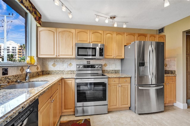 kitchen featuring light stone countertops, tasteful backsplash, stainless steel appliances, sink, and light brown cabinets