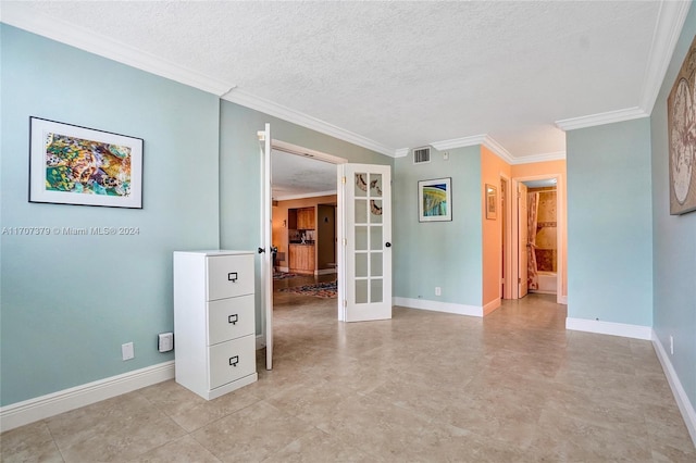 unfurnished room featuring a textured ceiling and ornamental molding