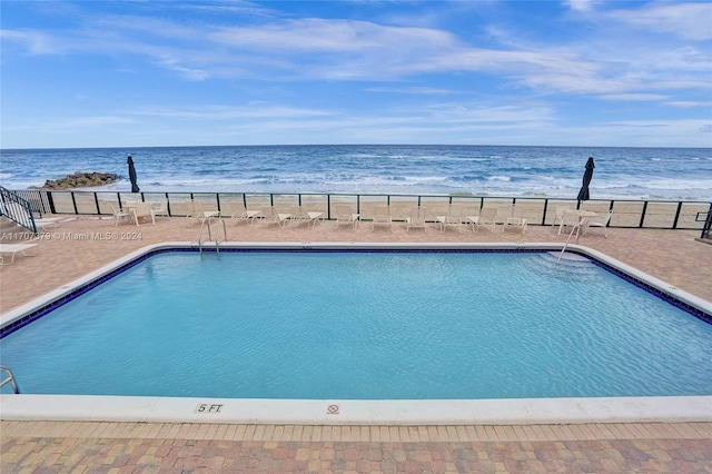 view of swimming pool featuring a water view