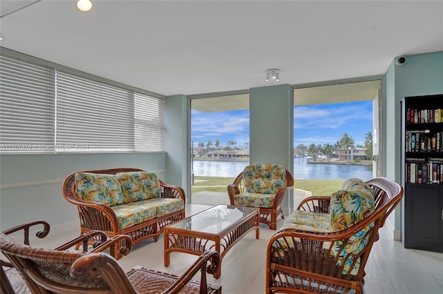 living area with a water view and a wall of windows