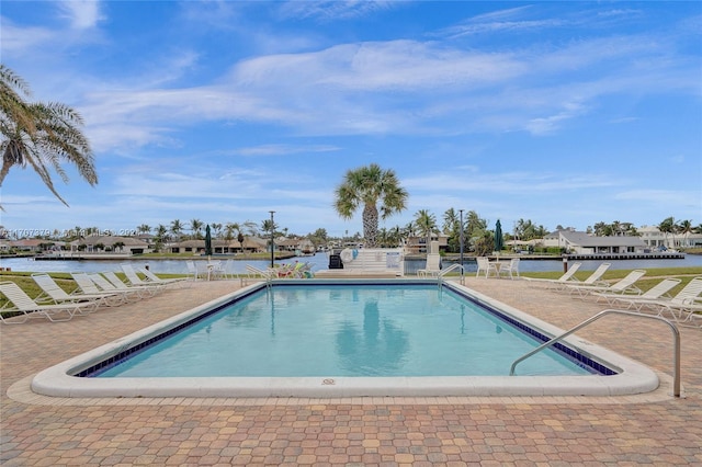 view of pool with a patio and a water view