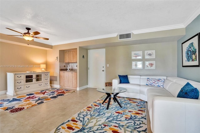 living room with ceiling fan, ornamental molding, and a textured ceiling