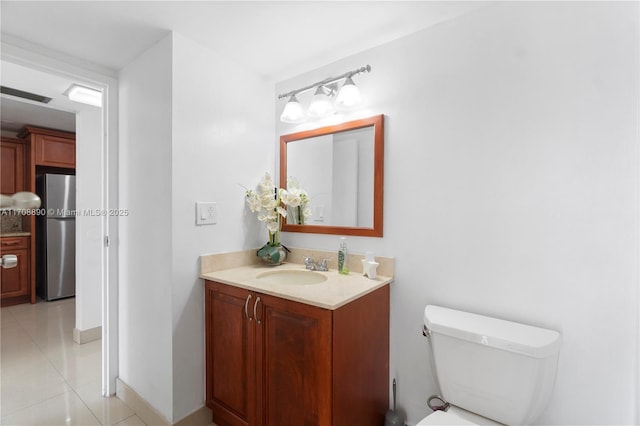 bathroom featuring toilet, tile patterned floors, and vanity