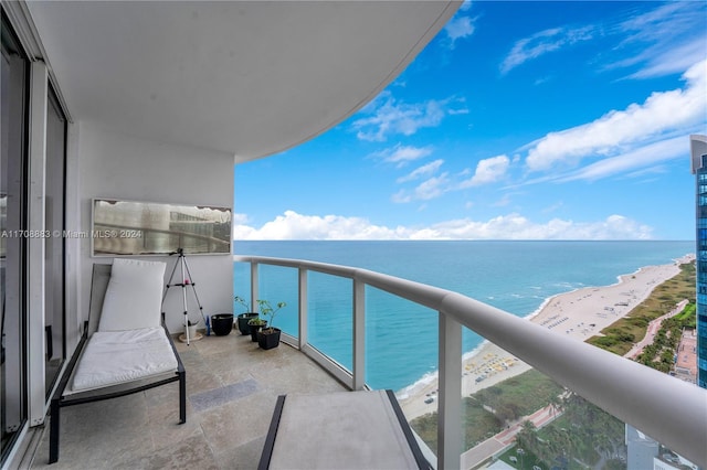 balcony featuring a water view and a beach view