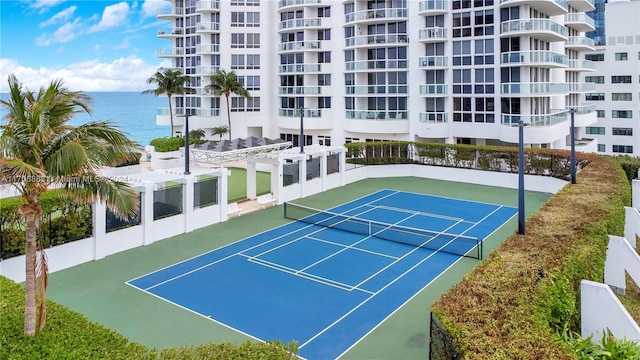 view of sport court with a water view and basketball hoop