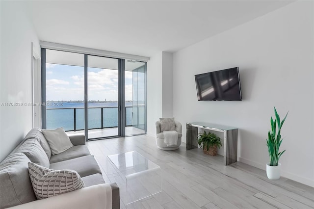 living room featuring wood finished floors, floor to ceiling windows, and baseboards