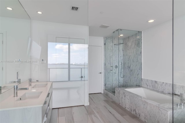 bathroom featuring separate shower and tub, vanity, and hardwood / wood-style flooring