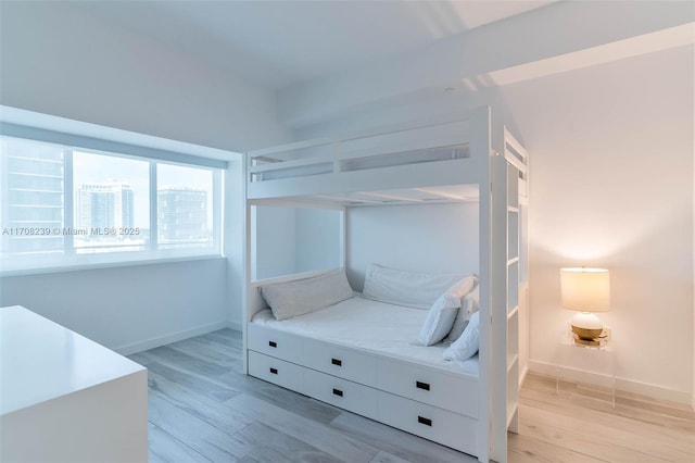 bedroom featuring light wood finished floors and baseboards