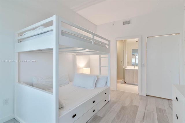 bedroom with visible vents and connected bathroom