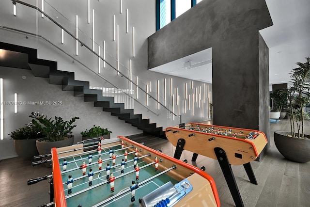 playroom featuring a high ceiling, wood finished floors, and baseboards