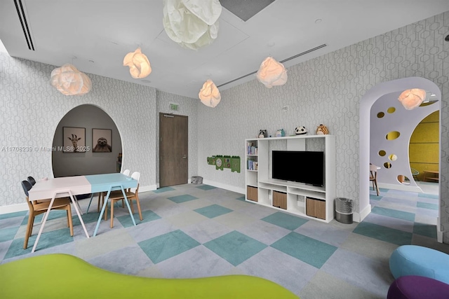 game room featuring arched walkways, wallpapered walls, baseboards, and tile patterned floors