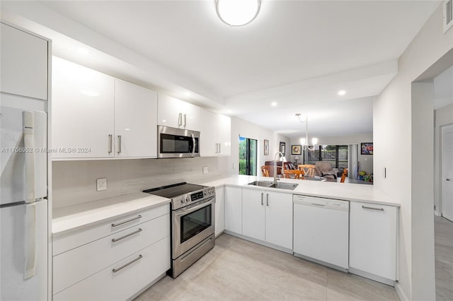 kitchen featuring decorative backsplash, kitchen peninsula, stainless steel appliances, sink, and white cabinetry