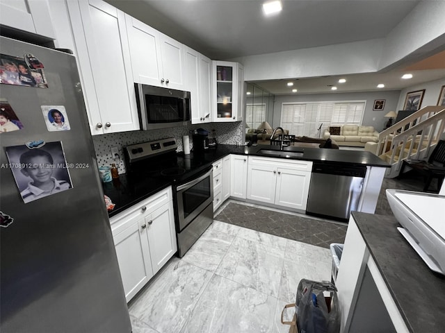 kitchen with kitchen peninsula, white cabinetry, and stainless steel appliances