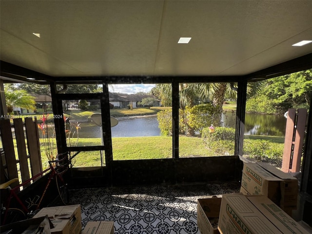 sunroom featuring a water view