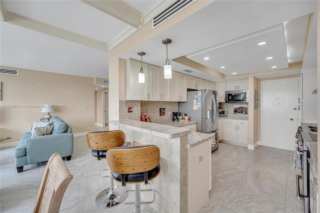 kitchen featuring kitchen peninsula, appliances with stainless steel finishes, backsplash, a kitchen breakfast bar, and pendant lighting