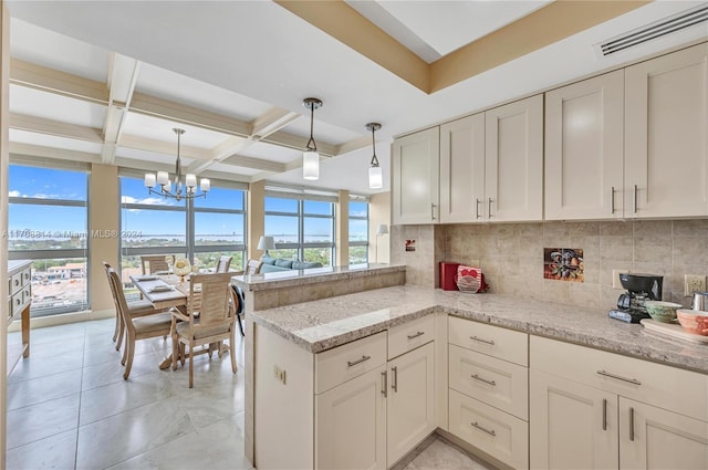 kitchen featuring kitchen peninsula, a wealth of natural light, hanging light fixtures, and coffered ceiling