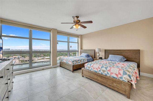 bedroom with ceiling fan and a water view