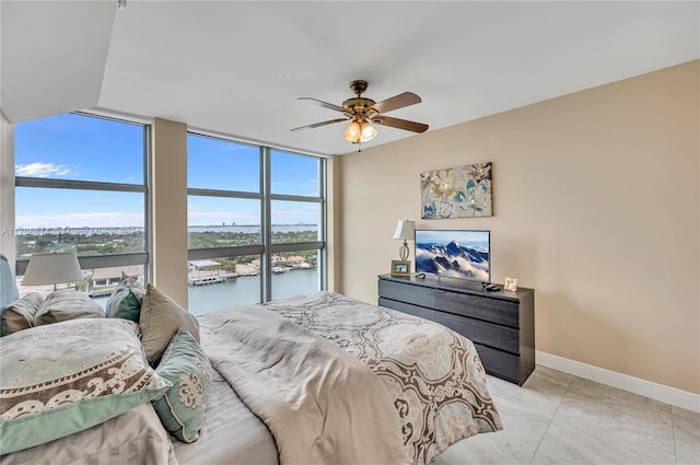 bedroom with light tile patterned floors, a wall of windows, and ceiling fan