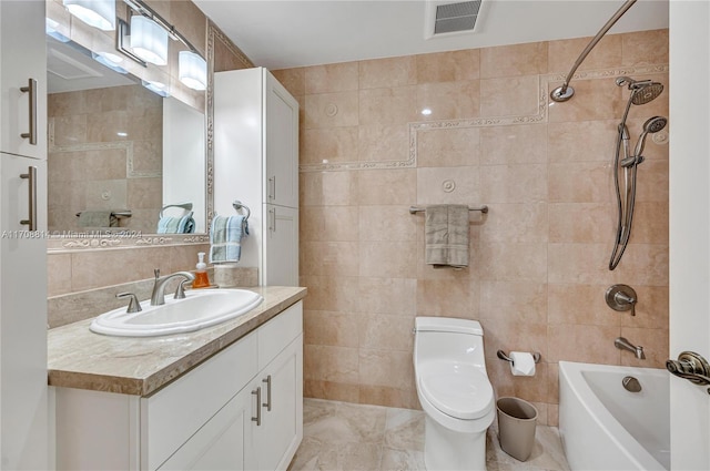 full bathroom with vanity, toilet, tile walls, and tiled shower / bath combo