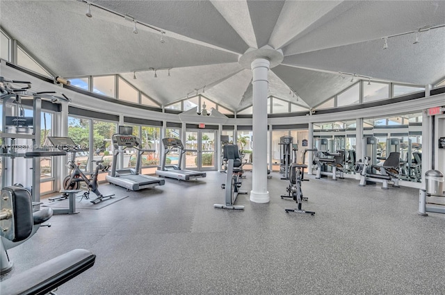 gym with a textured ceiling, track lighting, and a healthy amount of sunlight