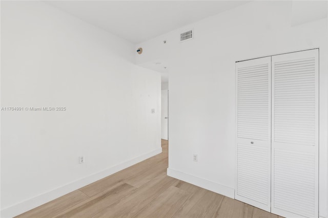 unfurnished bedroom with light hardwood / wood-style floors and a closet