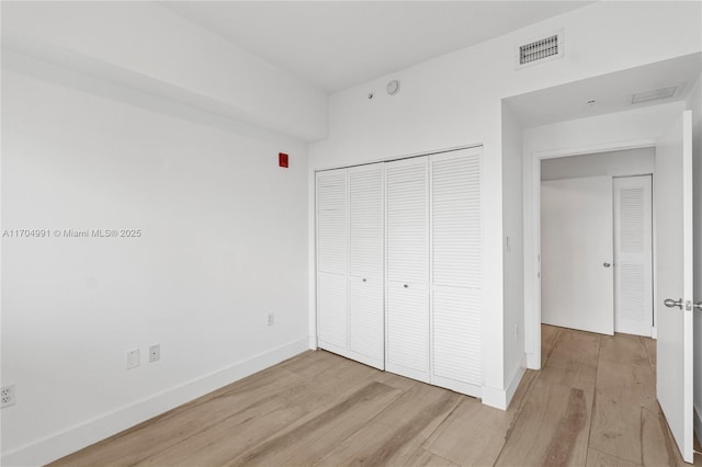 unfurnished bedroom with light hardwood / wood-style floors and a closet