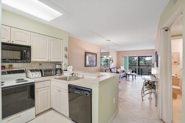 kitchen featuring kitchen peninsula, backsplash, sink, black appliances, and white cabinets