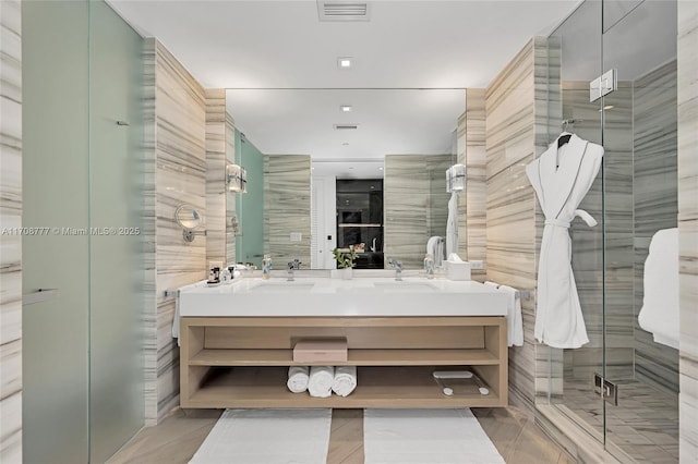 bathroom featuring vanity, tile walls, and a shower with door