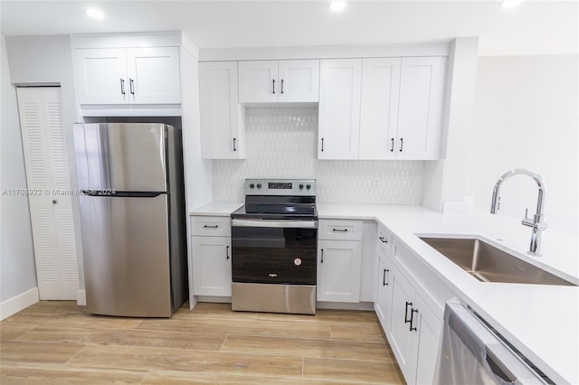 kitchen featuring sink, white cabinetry, stainless steel appliances, and light wood-type flooring