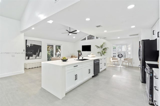 kitchen featuring sink, vaulted ceiling, an island with sink, appliances with stainless steel finishes, and white cabinetry