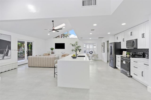 kitchen featuring white cabinetry, a center island with sink, a healthy amount of sunlight, and appliances with stainless steel finishes