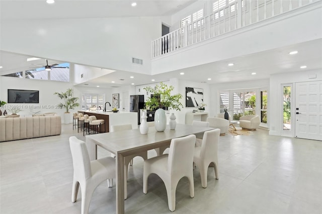 dining space featuring ceiling fan and a high ceiling