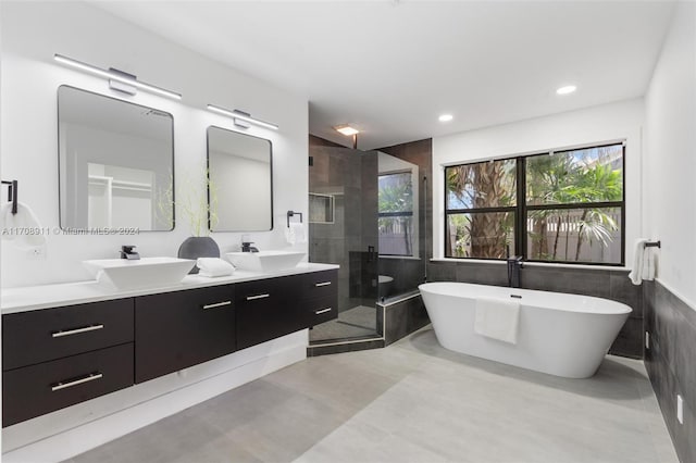 bathroom featuring shower with separate bathtub, vanity, and tile walls