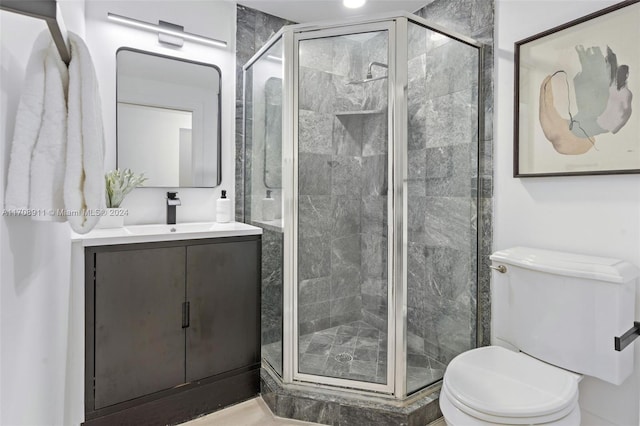 bathroom with an enclosed shower, vanity, and toilet