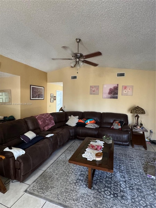 tiled living room with ceiling fan and a textured ceiling