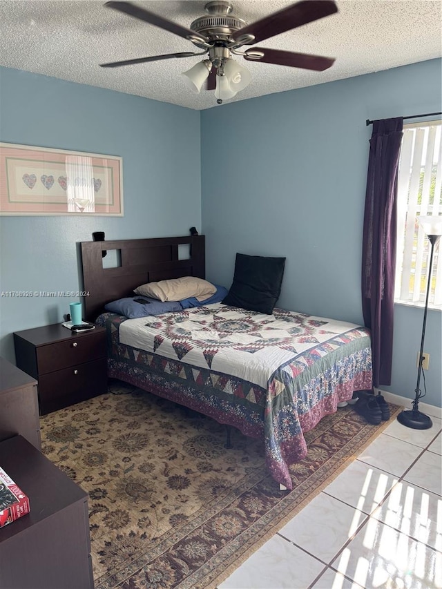 bedroom featuring light tile patterned floors, a textured ceiling, and ceiling fan