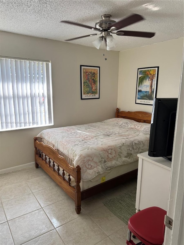 tiled bedroom with a textured ceiling and ceiling fan