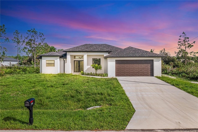 prairie-style house with a garage and a yard