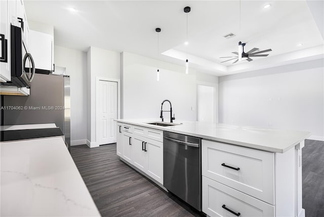 kitchen with appliances with stainless steel finishes, ceiling fan, sink, white cabinets, and hanging light fixtures