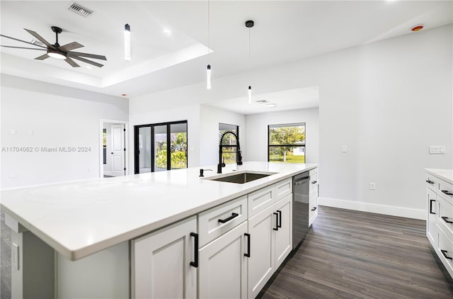 kitchen with white cabinetry, ceiling fan, dark wood-type flooring, stainless steel dishwasher, and a center island with sink