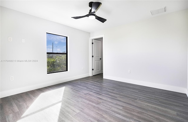 spare room featuring dark hardwood / wood-style floors and ceiling fan