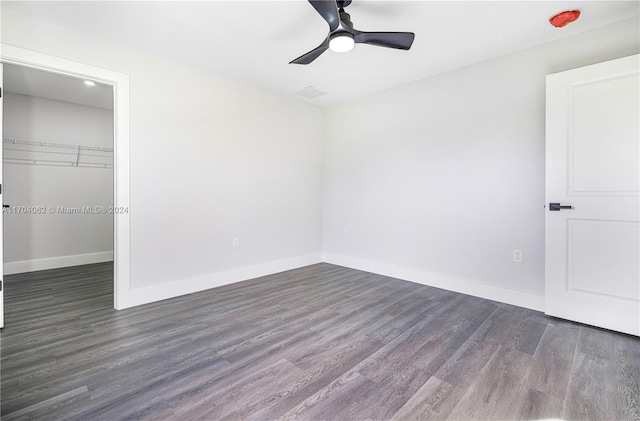 unfurnished room with ceiling fan and dark wood-type flooring