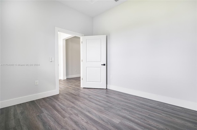 empty room with dark hardwood / wood-style flooring