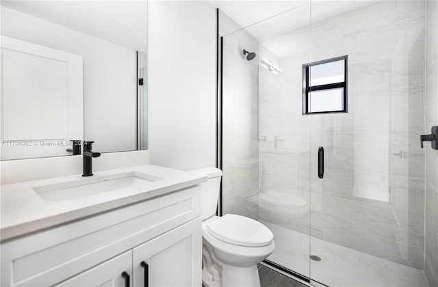 bathroom featuring vanity, toilet, and a shower with shower door