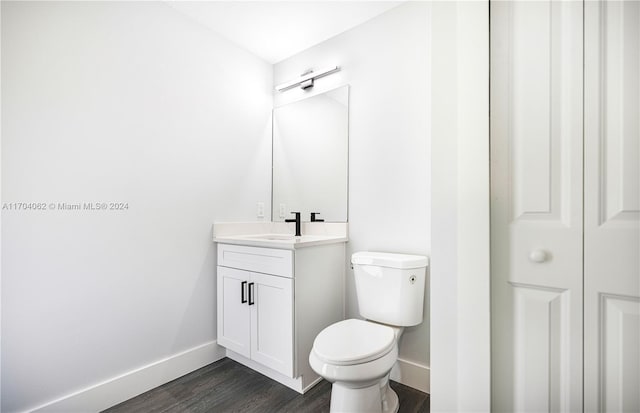 bathroom with vanity, wood-type flooring, and toilet