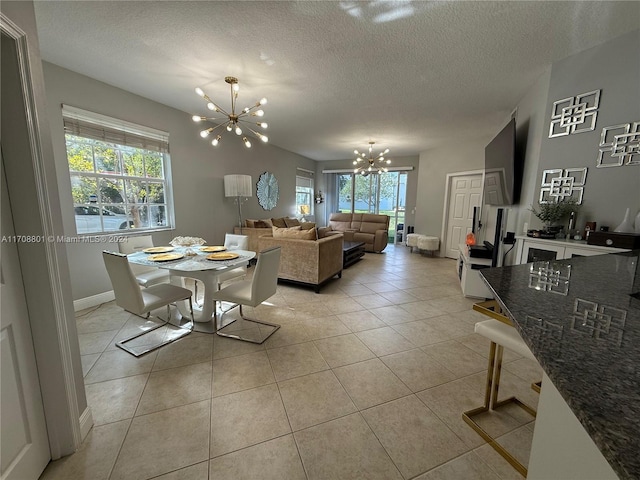 tiled dining room with plenty of natural light, a chandelier, and a textured ceiling