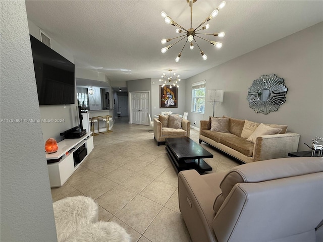 living room with light tile patterned floors, a textured ceiling, and an inviting chandelier