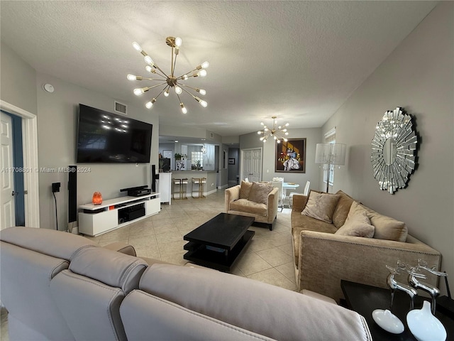 living room featuring a notable chandelier, light tile patterned floors, and a textured ceiling